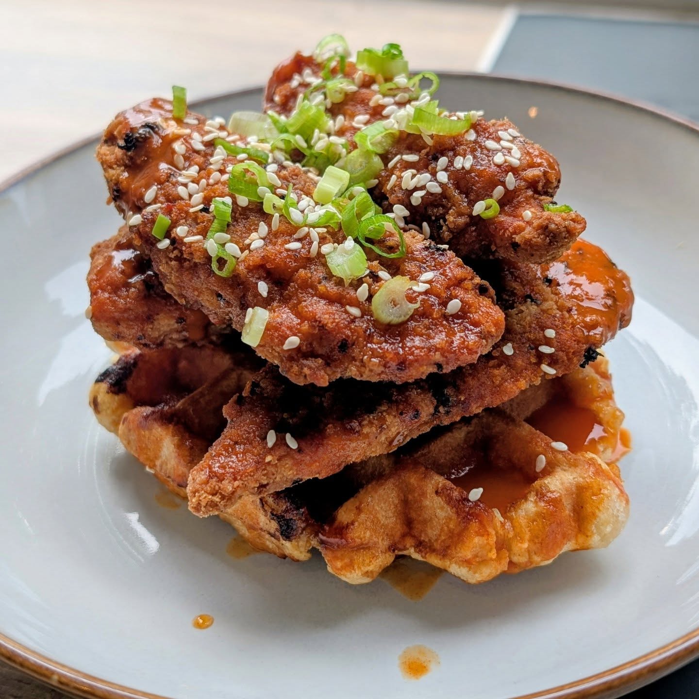 Chicken waffles with hot honey, scallions and sesame seeds