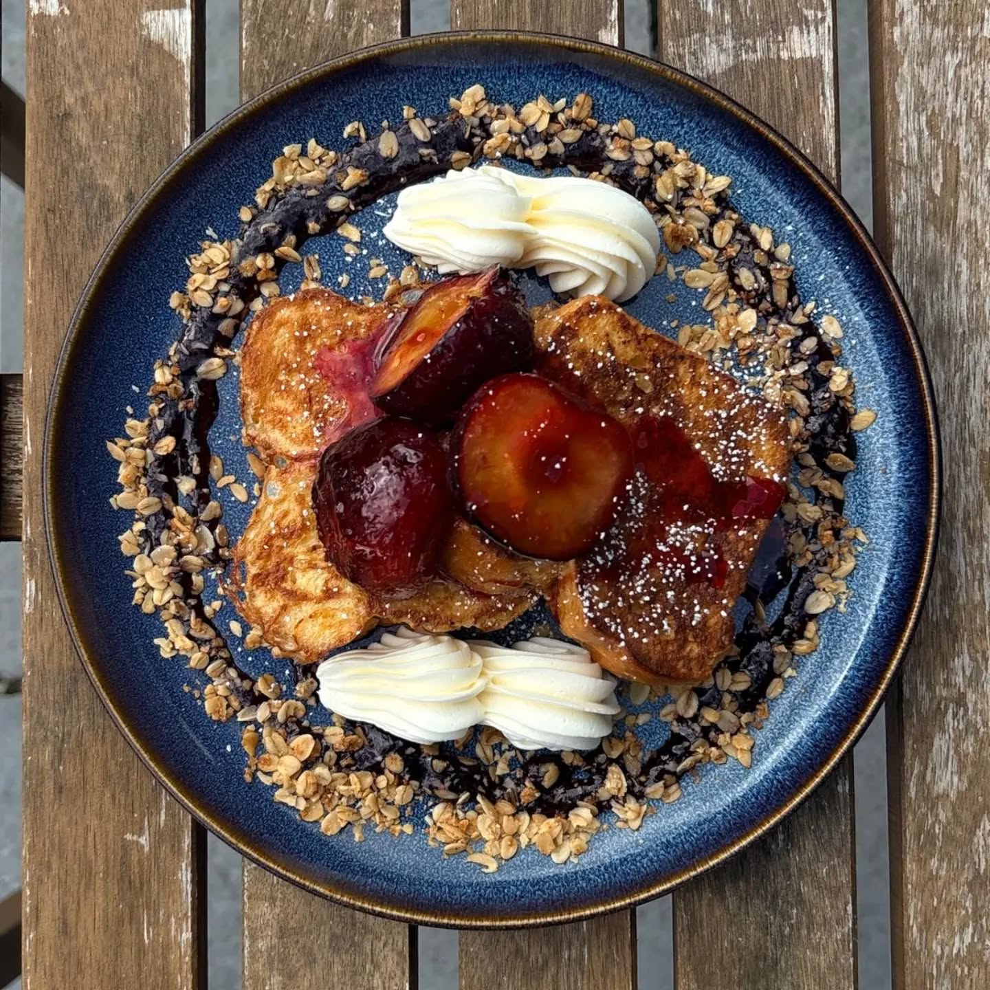 French toast with caramelised plums, cream and granola