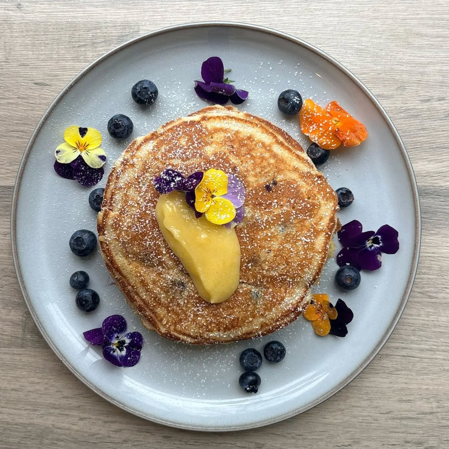 Blueberry pancakes with lemon curd and edible flowers